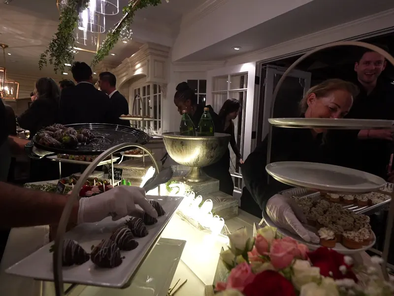 Server carrying a dessert tray at an indoor Danville party