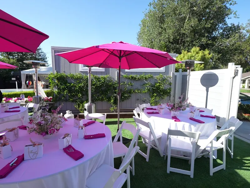 Umbrella tables with floral centerpieces at a Danville backyard shower
