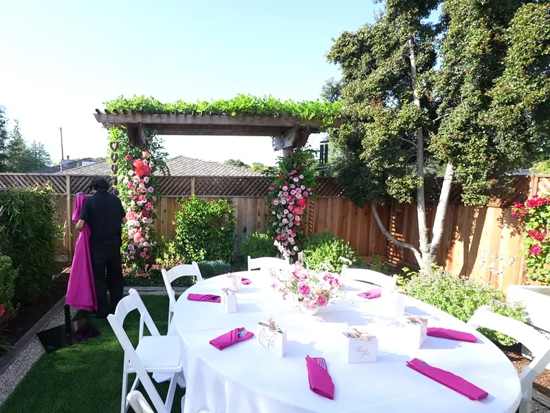 Floral arch beside a round table set for a Diablo backyard event