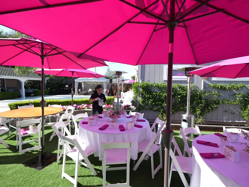 Lawn tables with umbrellas set for a Pittsburg backyard party