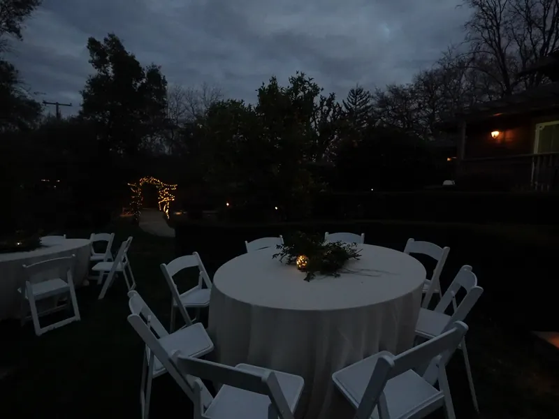 Round garden table set at dusk for an Alamo dinner