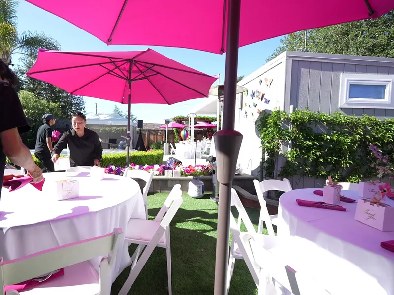 Sunny backyard tables with umbrellas set for an Antioch party