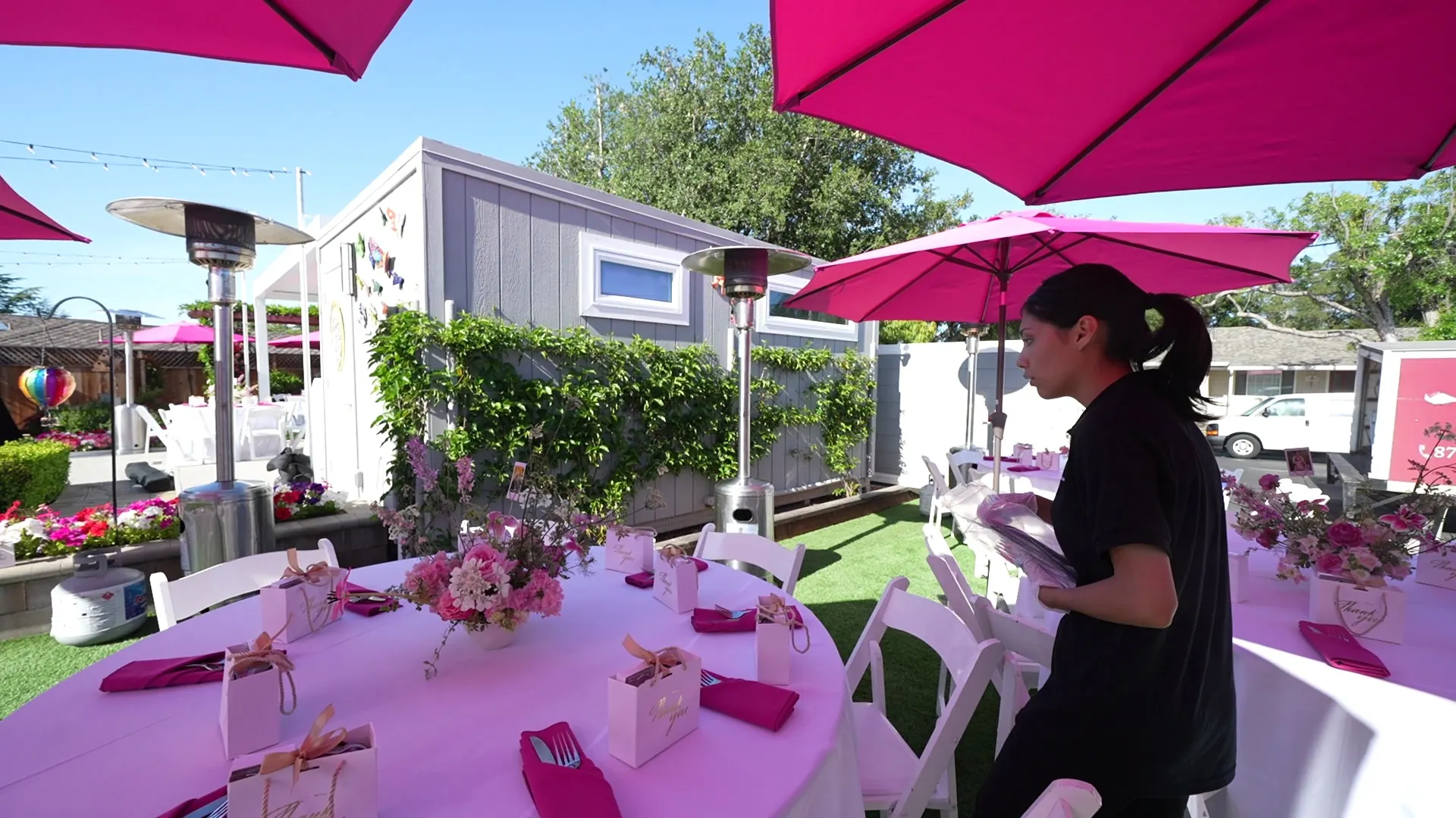 Backyard tables with pink umbrellas and floral centerpieces at a Walnut Creek celebration