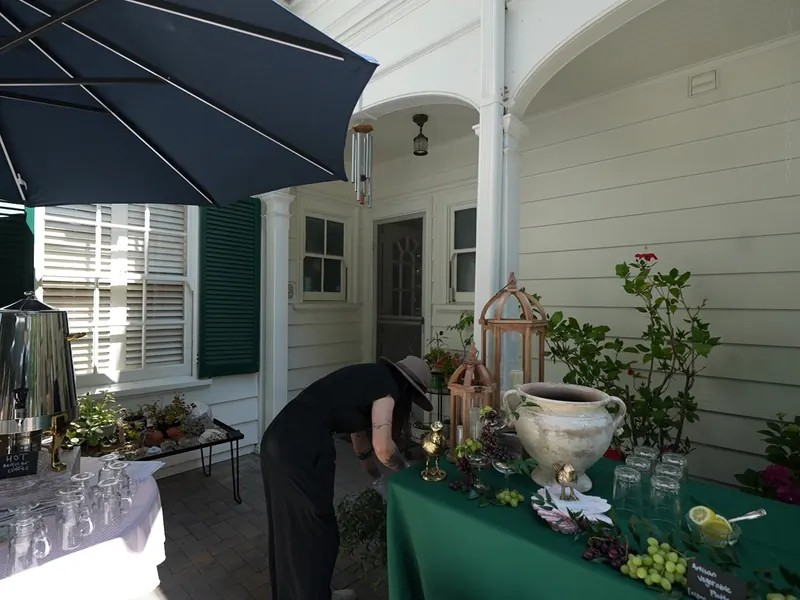 Server setting a dessert table under a patio umbrella at a Walnut Creek home