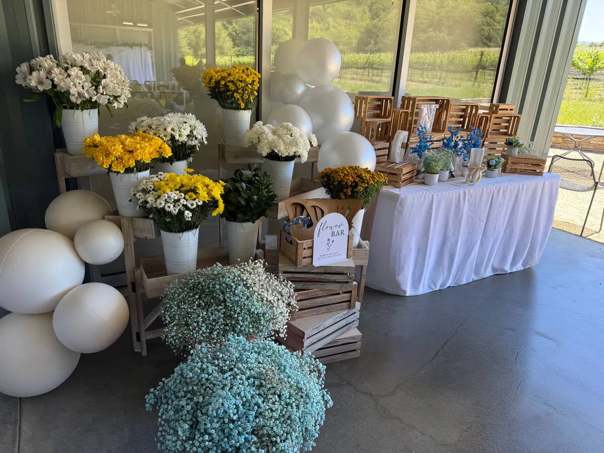 Bloom bar stocked with yellow roses, daisies and baby's breath alongside ribbon and paper for guests to wrap their own bouquets — bloom bar experience from Pittsburg catering