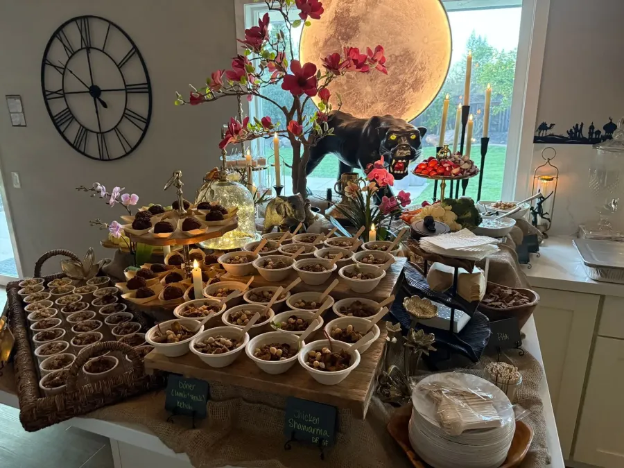 Mediterranean buffet of shawarma chicken, kebob and mezze framed by low seasonal arrangements — floral accents for Martinez catering dinners