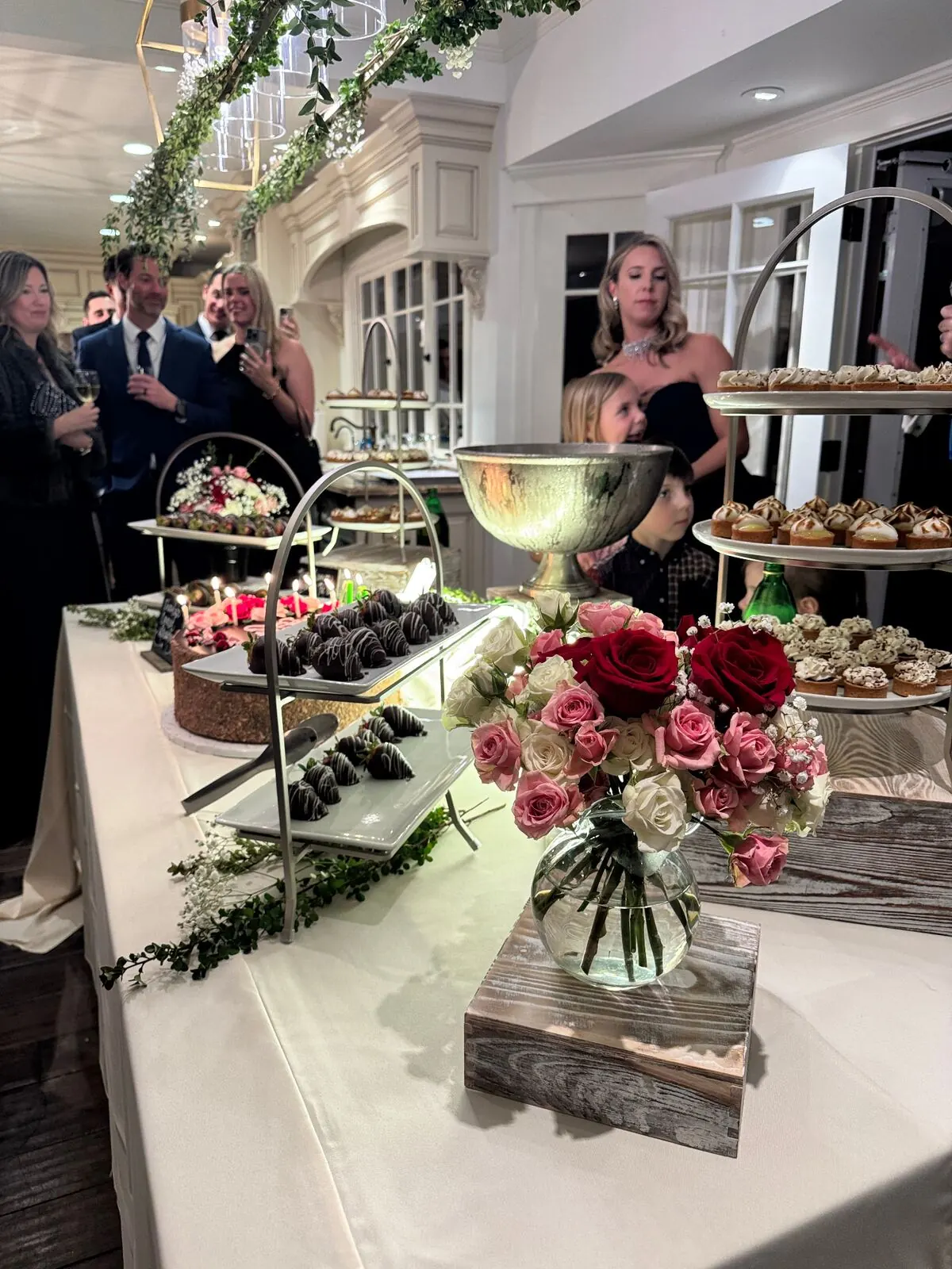 Reception sweets table of chocolate-shelled berries and petite pastries surrounded by fresh garden roses — wedding dessert florals for Diablo catering